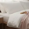 A bedroom scene with a freshly made bed, silk pjs and a gold vibrator