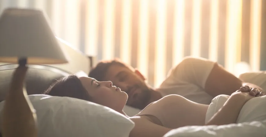 The attractive woman sleeping near a man in the comfortable bed. night time